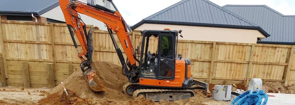 Drainage Systems excavator preparing a tank excavation on a residential site